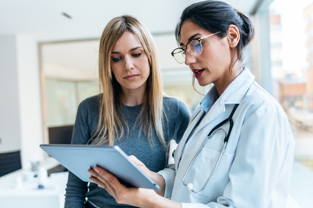 Shot Of Beautiful Female Doctor Talking While Explaining Medical Treatment to Another Lady